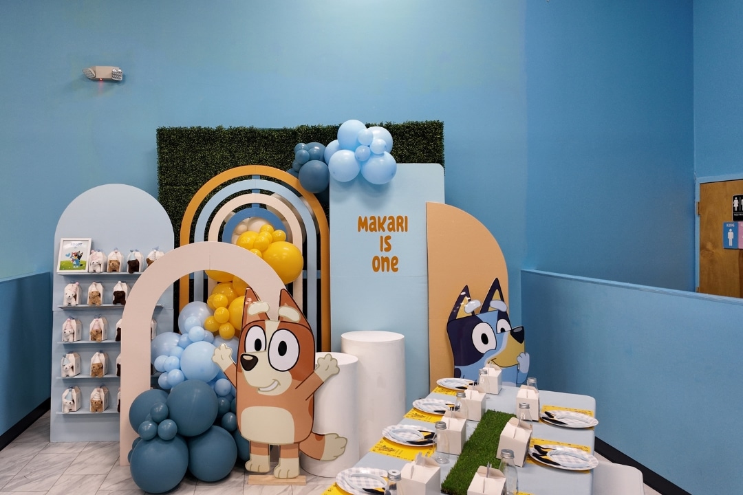 Bluey and Bingo first birthday party with custom character cutouts and rainbow backdrop at Kidz Kastle RI