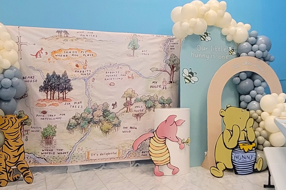 Vintage Winnie the Pooh themed first birthday with 100 Aker Wood map backdrop and honey pot props at Kidz Kastle RI