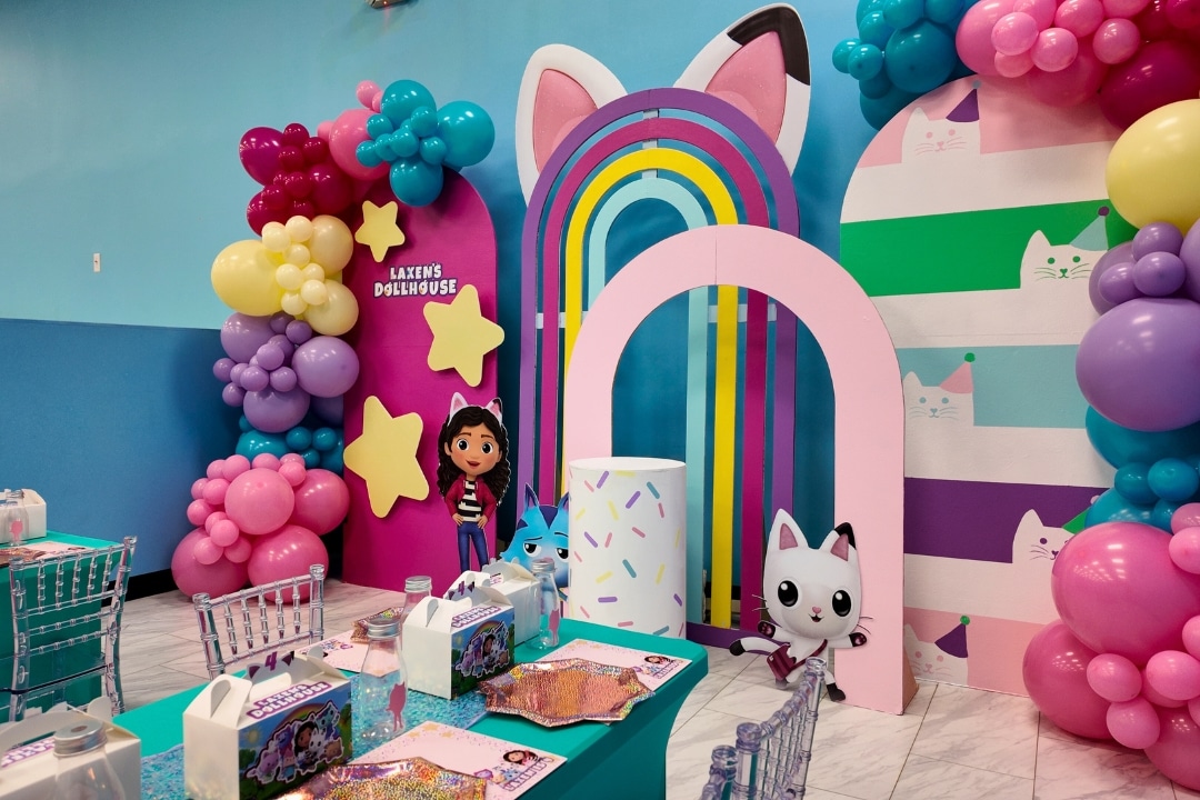Gabbys Dollhouse themed birthday party with rainbow arches and character cutouts at Kidz Kastle RI