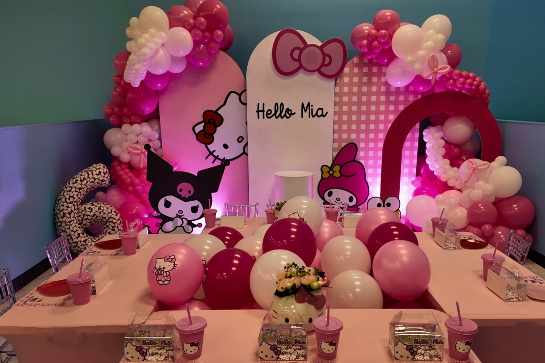 Hello Kitty and Kuromi themed birthday party with pink balloon arches and custom backdrops at Kidz Kastle RI