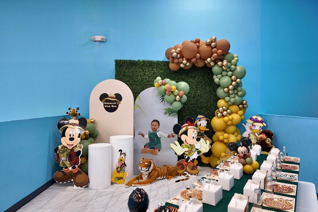 Mickey Safari Wild One themed first birthday party with jungle greenery and animal props at Kidz Kastle RI