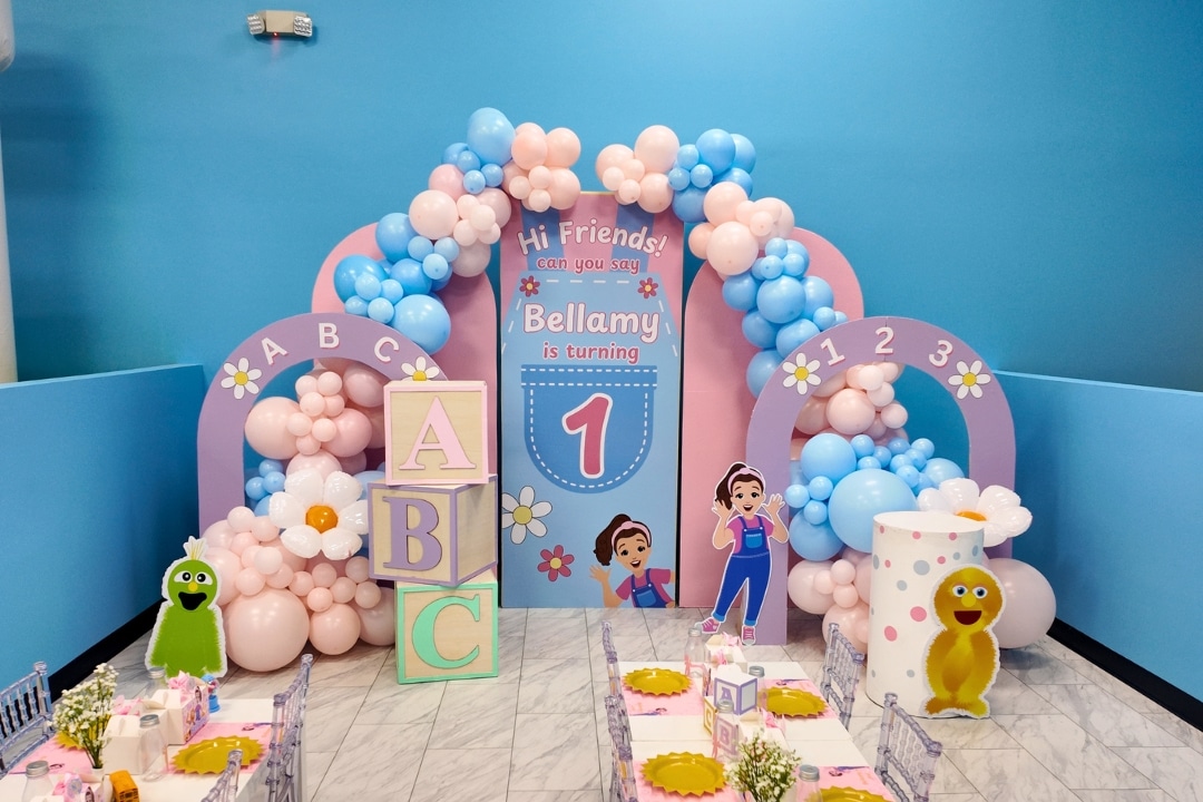 Ms. Rachel themed first birthday party with pastel balloon arches and ABC blocks at Kidz Kastle.