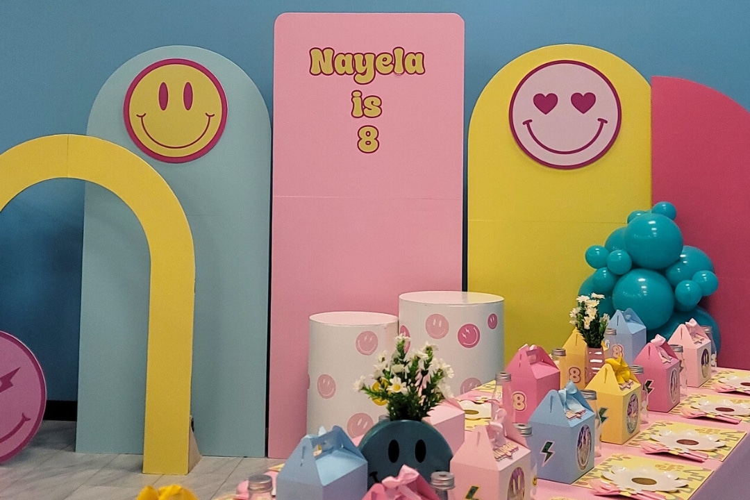 A colorful retro smiley face themed 8th birthday party for Nayela with custom arch backdrops and groovy decor at Kidz Kastle