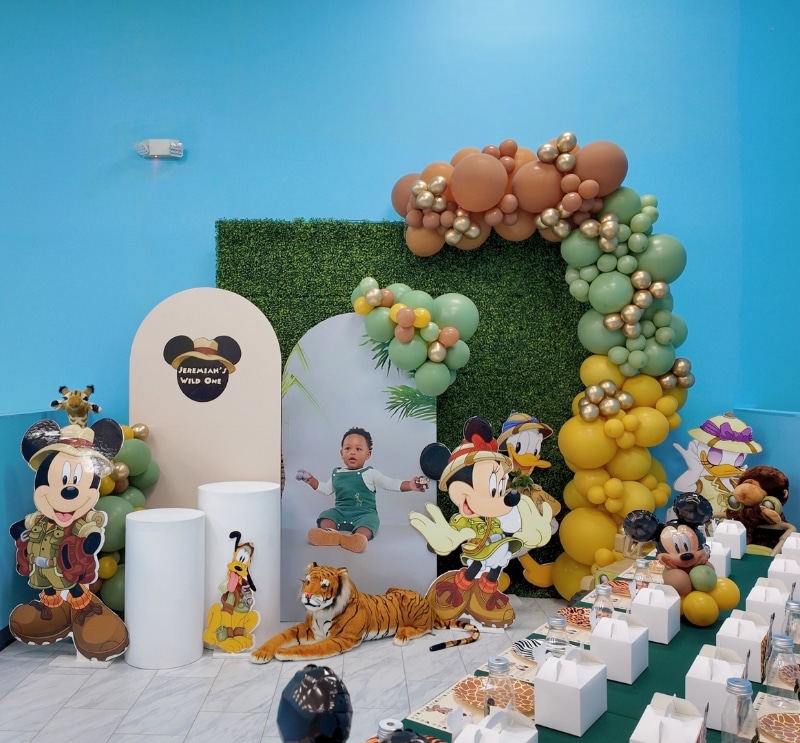 Safari-themed birthday party with jungle decor and balloon garland inspired by classic characters.