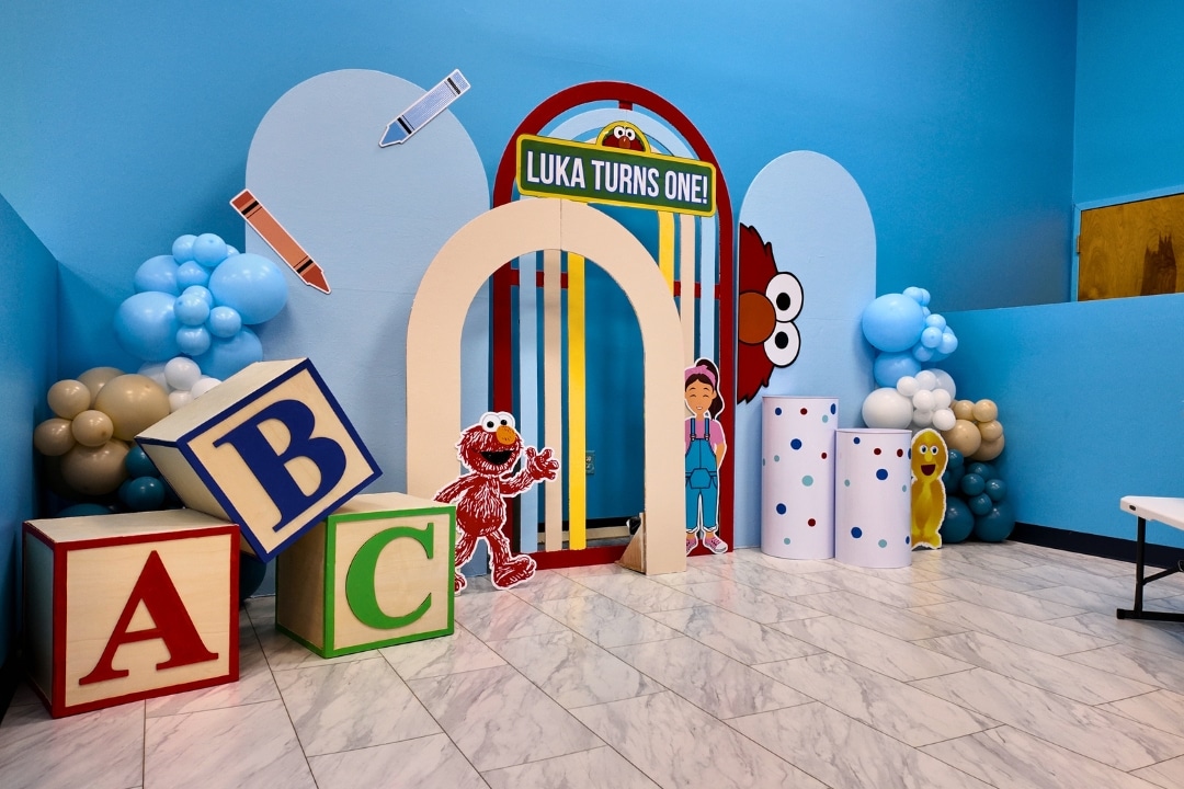 Sesame Street Elmo first birthday party for Luka with ABC block props, Elmo and character cutouts, and balloon clusters at Kidz Kastle in Rhode Island.