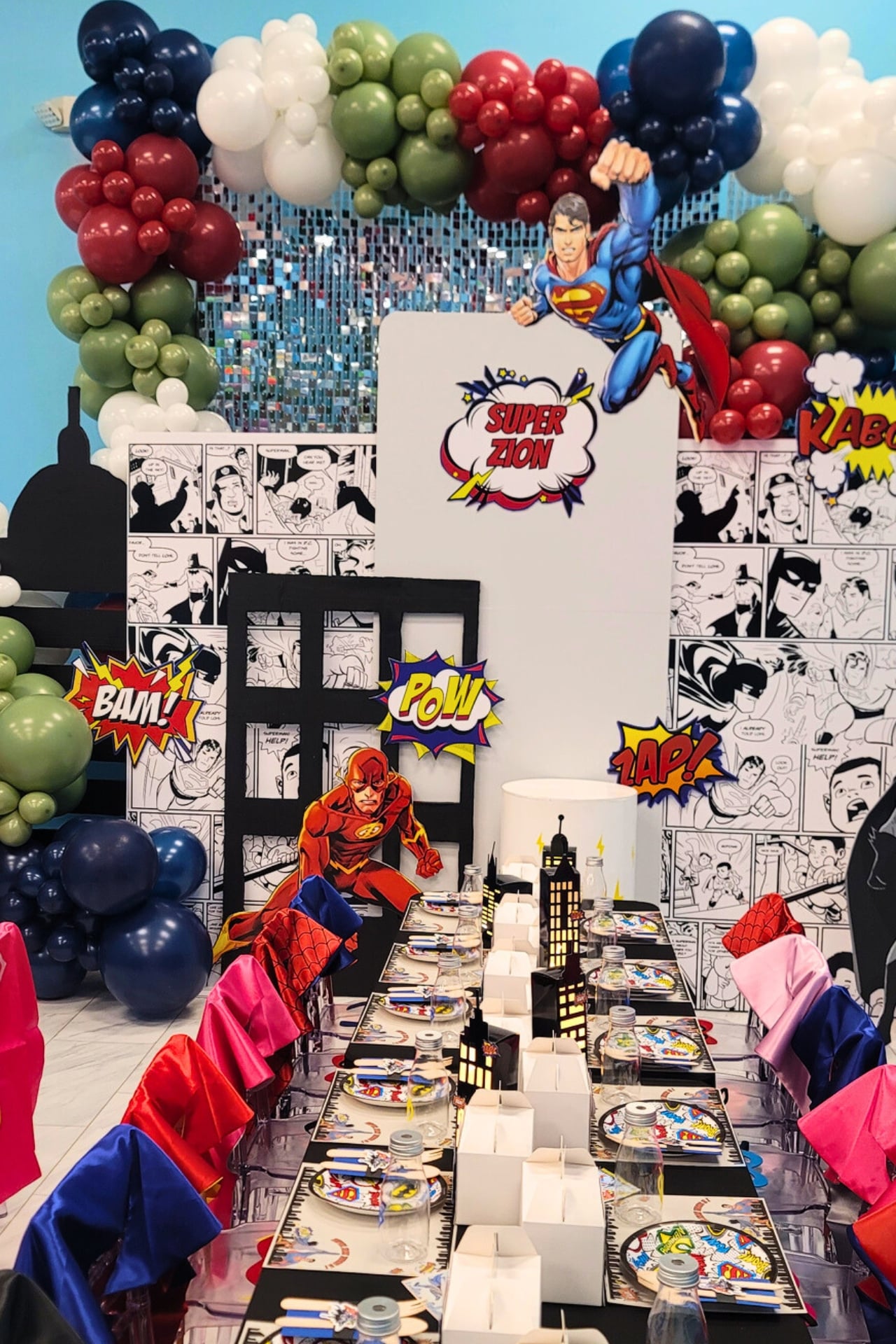 Superhero themed birthday party with comic-style decor and custom balloon garland.