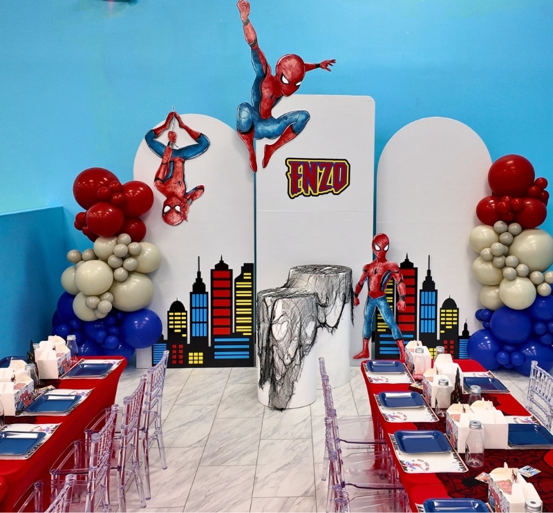 Action-packed Spider-Man themed birthday party with city skyline backdrop and custom balloon garland.