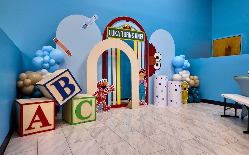 Sesame Street themed first birthday party at Kidz Kastle private indoor party venue in Warwick Rhode Island with Elmo character props ABC blocks and balloon decor
